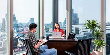 Client meeting and collaborating in a fully equipped serviced office with a stunning city view.