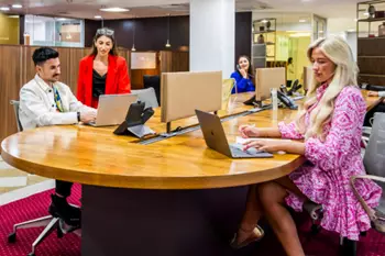 Coworking Space with high table at 1 Mayfair Place with people networking and working while using their technologies.